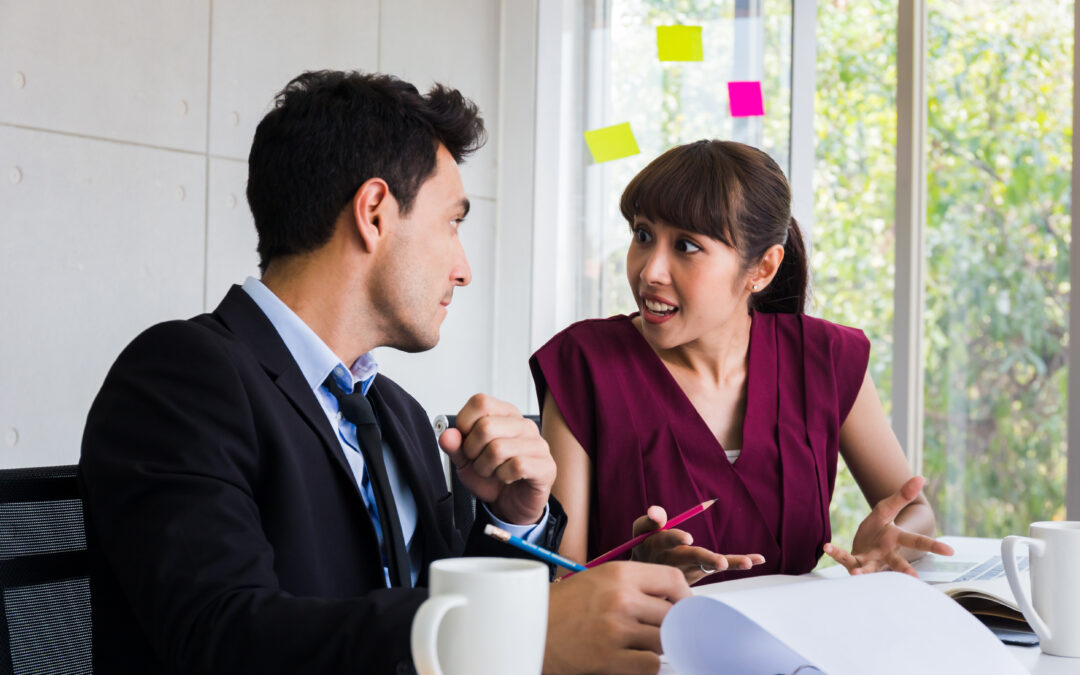 Confused male and female employees at desk discuss work problems and technology solutions in Circleville, Ohio